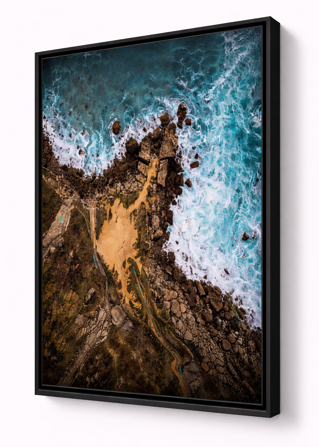 aluminum artbox framed artwork of an aerial view of a coastal landscape with waves crashing against rocks.