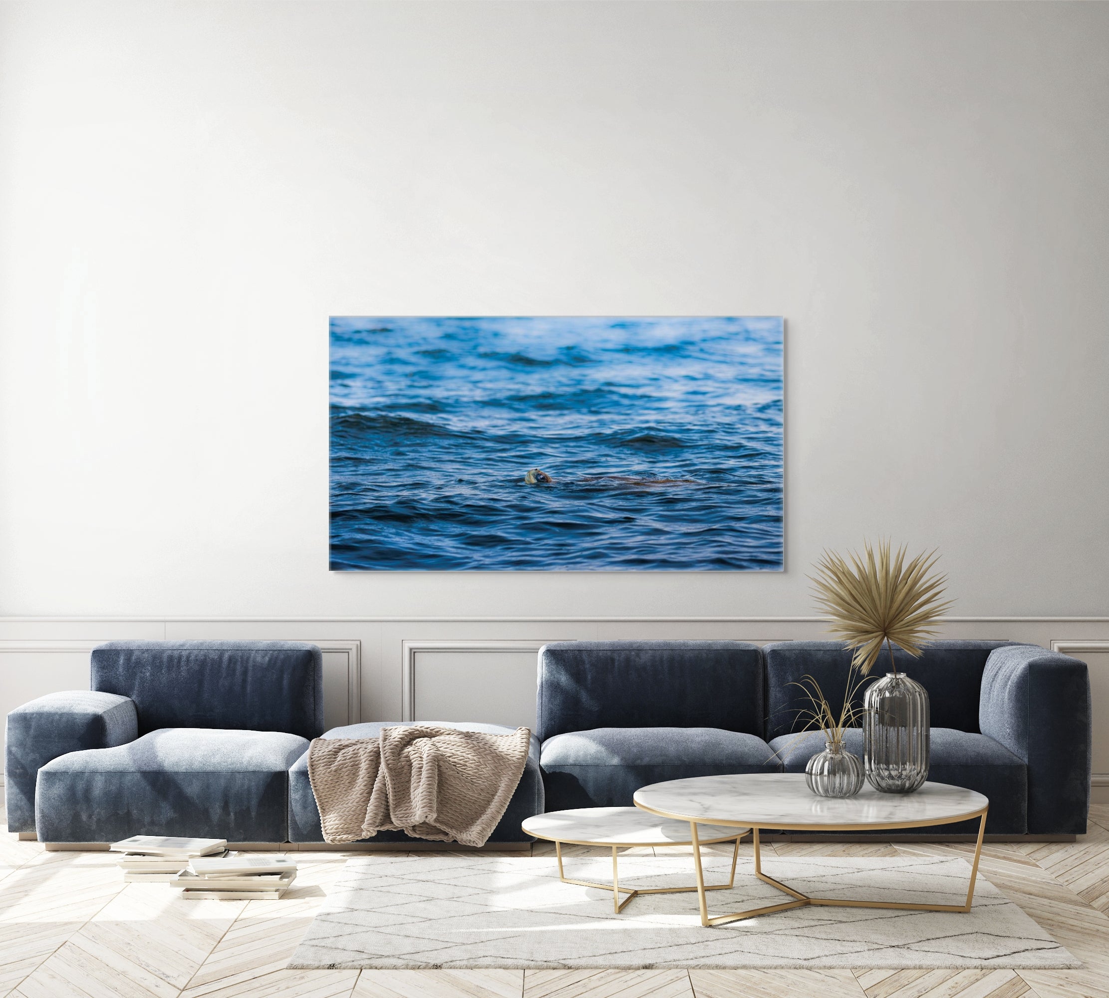 Modern living room with a large ocean painting on the wall above a sofa.